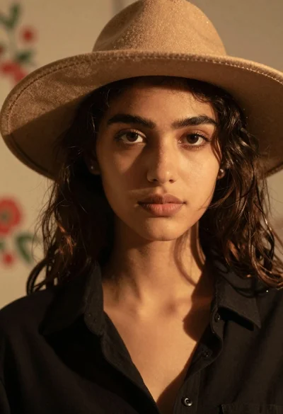 Portrait of woman in hat with warm golden background
