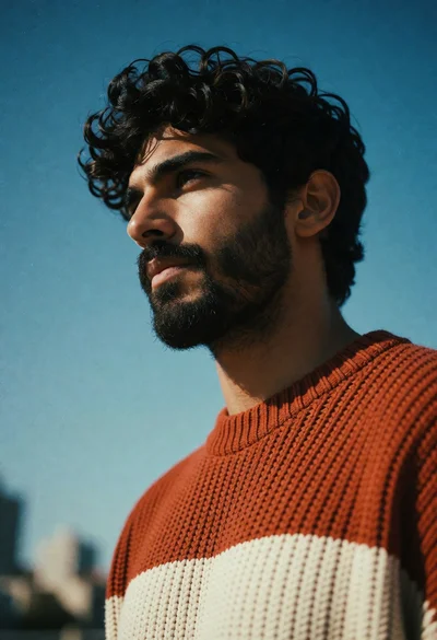 Low angle portrait of man in knit sweater against clear blue sky