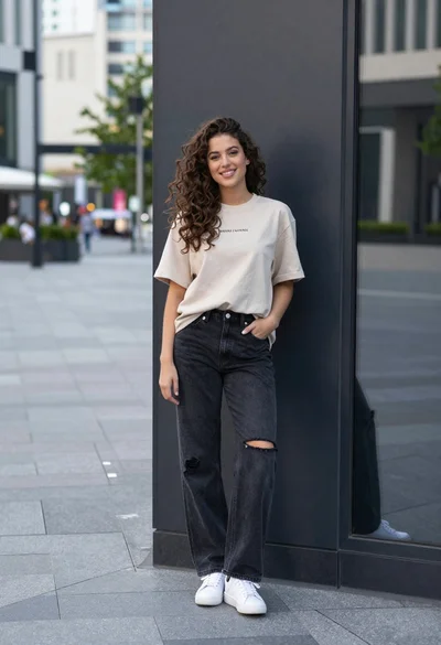 Young woman in beige tshirt leaning against glass wall in urban plaza